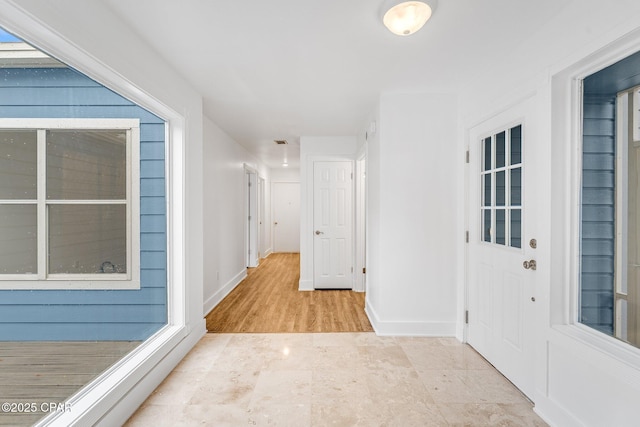 hallway with visible vents and baseboards
