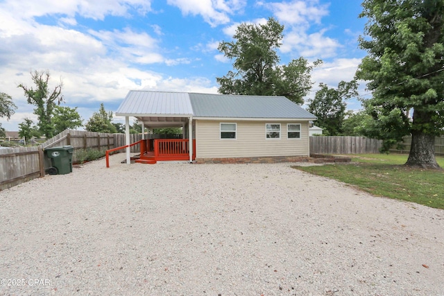 911 Indiana Ave, Lynn Haven, FL 32444 - back of property with gravel driveway, a metal roof, and a fenced backyard