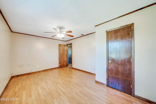 unfurnished bedroom featuring wood finished floors, ornamental molding, baseboards, and a textured ceiling