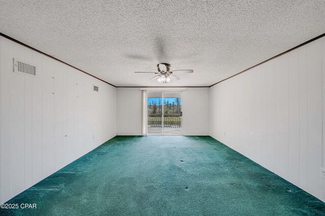 carpeted spare room featuring ornamental molding, visible vents, and a ceiling fan