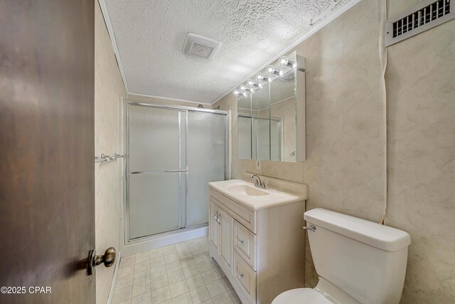 bathroom featuring a stall shower, toilet, vanity, and a textured ceiling
