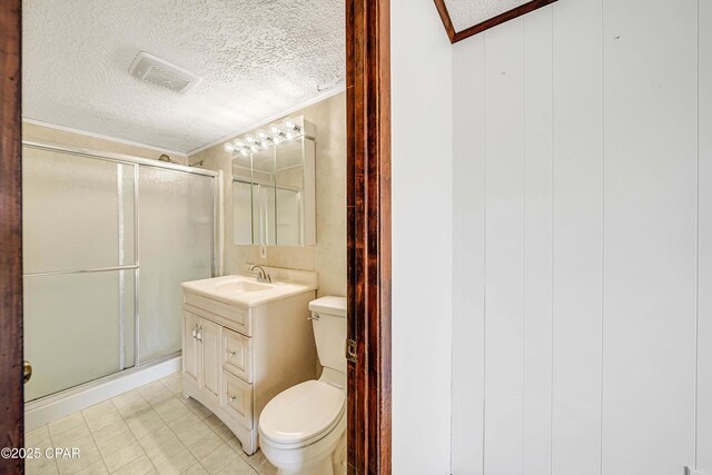 bathroom featuring a shower stall, crown molding, toilet, and a textured ceiling