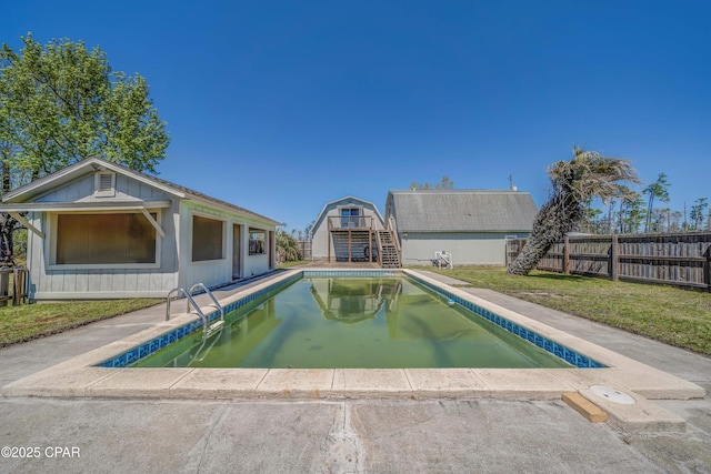view of pool featuring stairs, a fenced in pool, a fenced backyard, a lawn, and an outdoor structure