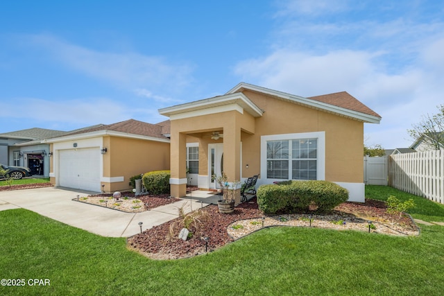 view of front of house featuring an attached garage, stucco siding, fence, and a front yard