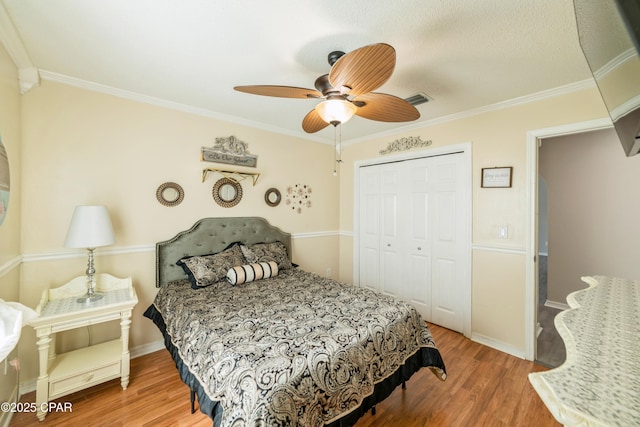bedroom with crown molding, a closet, and wood finished floors