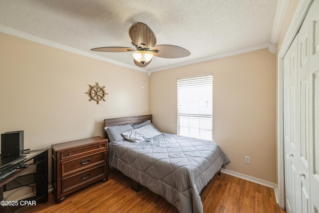 bedroom with a closet, a textured ceiling, crown molding, ceiling fan, and wood finished floors
