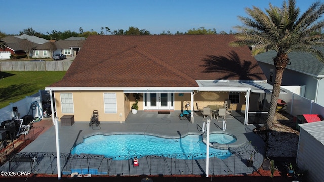 rear view of property featuring a fenced backyard, stucco siding, a patio, an in ground hot tub, and a fenced in pool