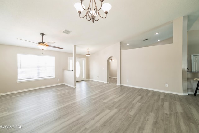 unfurnished living room with wood finished floors, ceiling fan with notable chandelier, baseboards, and visible vents