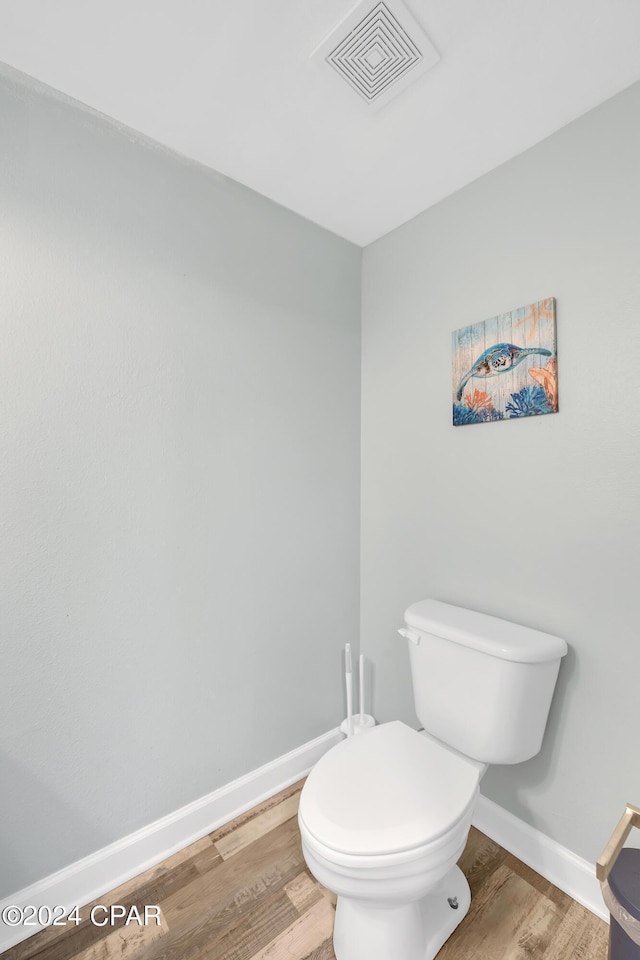 bathroom featuring wood finished floors, toilet, baseboards, and visible vents