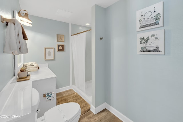 full bathroom with toilet, a stall shower, baseboards, and wood finished floors