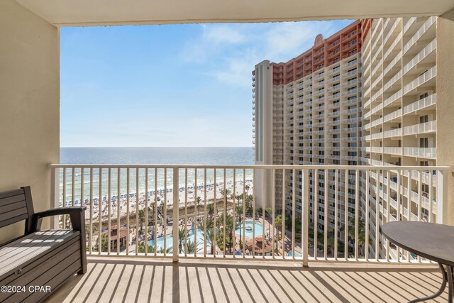 balcony featuring a water view and a beach view