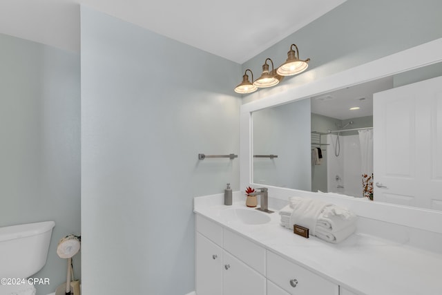 bathroom with toilet, vanity, and curtained shower