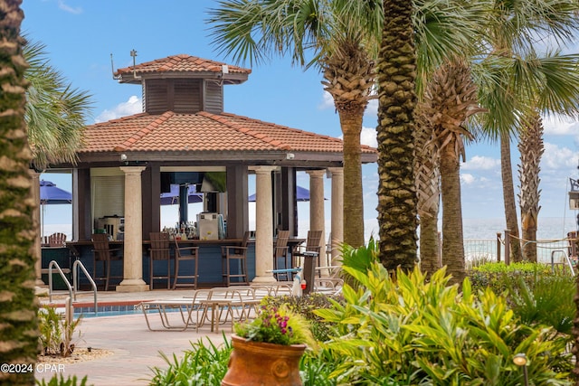 back of property featuring a tiled roof and a gazebo