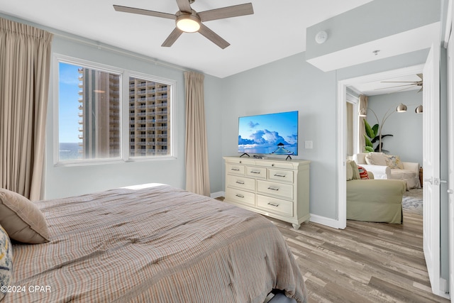 bedroom featuring baseboards, ceiling fan, and light wood finished floors