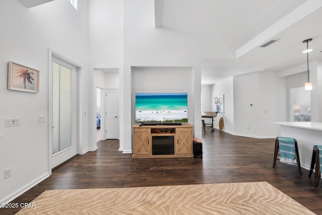8453 Landshark Blvd, Panama City Beach, FL 32413 - living room featuring dark wood-type flooring, baseboards, visible vents, and a towering ceiling