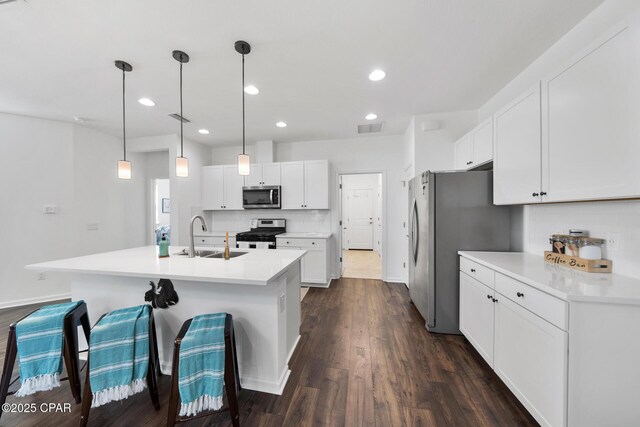 8453 Landshark Blvd, Panama City Beach, FL 32413 - kitchen featuring dark wood finished floors, tasteful backsplash, white cabinetry, a sink, and stainless steel appliances