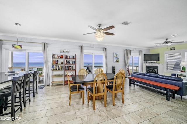123 Sapodilla Ln, Port St Joe, FL 32456 - dining space with a ceiling fan, crown molding, a water view, and a fireplace