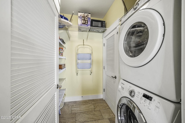 123 Sapodilla Ln, Port St Joe, FL 32456 - washroom with stacked washing machine and dryer, stone tile floors, and baseboards