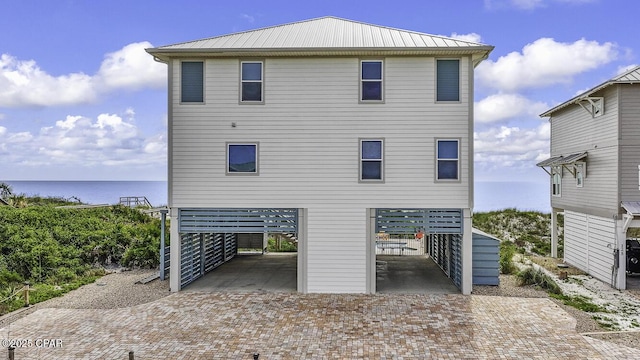 123 Sapodilla Ln, Port St Joe, FL 32456 - rear view of house with a carport, decorative driveway, metal roof, a water view, and a patio