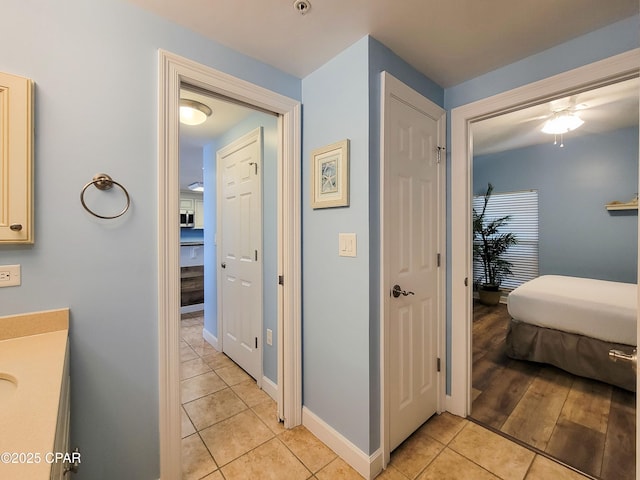 hallway featuring light tile patterned flooring and baseboards