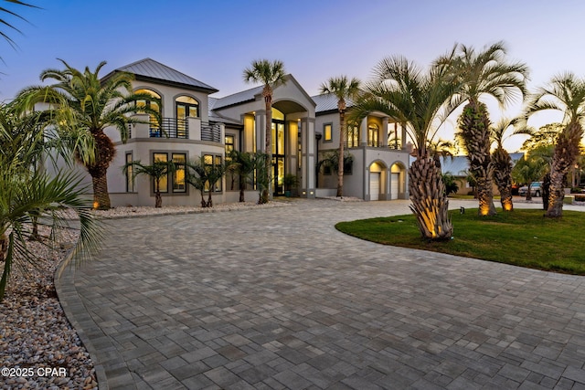 4522 Bay Point Rd, Panama City Beach, FL 32408 - view of front of home featuring a balcony, metal roof, a front yard, stucco siding, and curved driveway