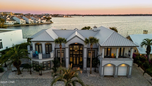 4522 Bay Point Rd, Panama City Beach, FL 32408 - view of front of property featuring a standing seam roof, stucco siding, a balcony, metal roof, and a water view