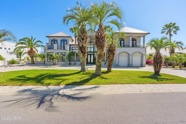4522 Bay Point Rd, Panama City Beach, FL 32408 - mediterranean / spanish house with stucco siding, an attached garage, a balcony, driveway, and a front yard