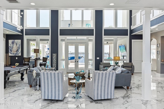 4522 Bay Point Rd, Panama City Beach, FL 32408 - living area featuring french doors, marble finish floor, a towering ceiling, arched walkways, and visible vents