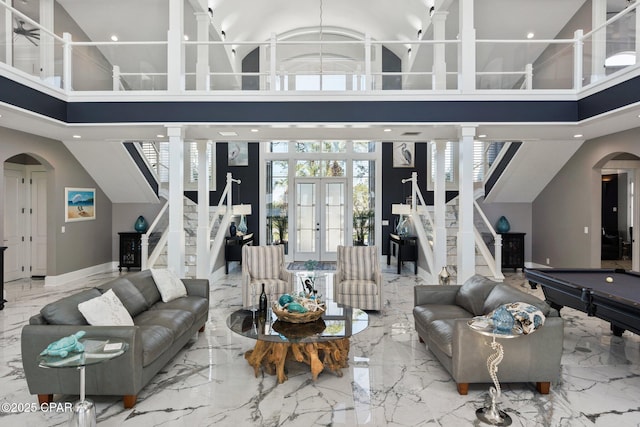 4522 Bay Point Rd, Panama City Beach, FL 32408 - living room featuring arched walkways, a towering ceiling, french doors, and stairway