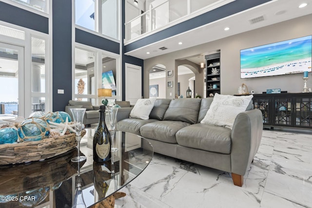 4522 Bay Point Rd, Panama City Beach, FL 32408 - living room with marble finish floor, a wealth of natural light, arched walkways, and visible vents