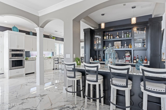 4522 Bay Point Rd, Panama City Beach, FL 32408 - bar with marble finish floor, stainless steel double oven, decorative light fixtures, and wet bar