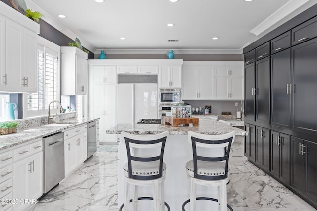 4522 Bay Point Rd, Panama City Beach, FL 32408 - kitchen with white cabinetry, a center island, marble finish floor, a sink, and built in appliances