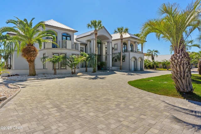 4522 Bay Point Rd, Panama City Beach, FL 32408 - mediterranean / spanish-style home featuring a balcony, curved driveway, stucco siding, and metal roof