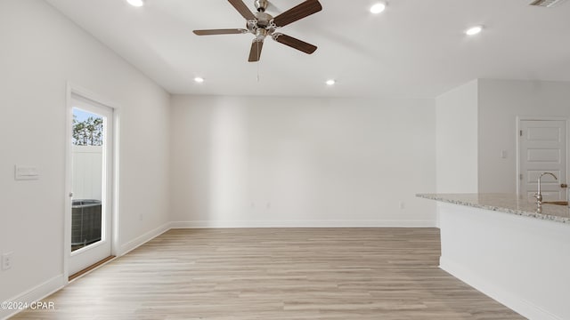 empty room with a sink, a ceiling fan, recessed lighting, and light wood-style flooring