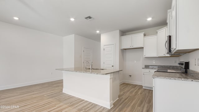 kitchen featuring a sink, baseboards, white cabinets, electric stove, and light wood-style flooring