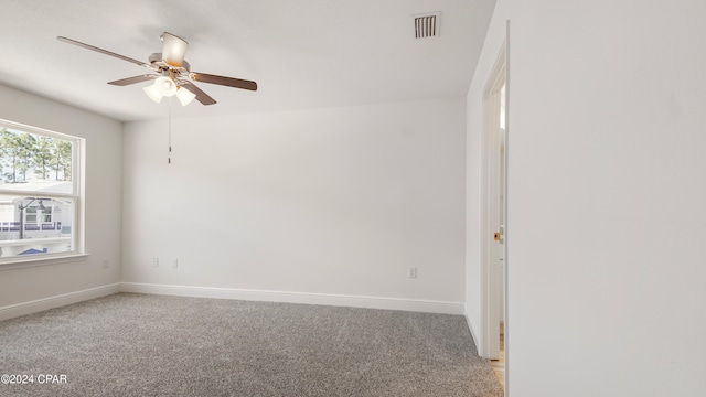 spare room with baseboards, light carpet, a ceiling fan, and visible vents