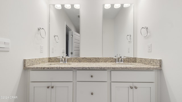 full bathroom with double vanity and a sink
