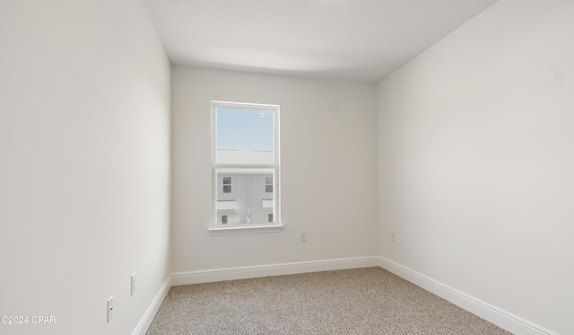 unfurnished room with carpet floors and baseboards
