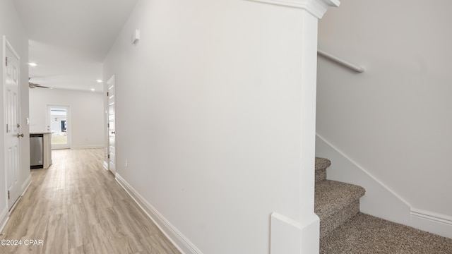hallway featuring recessed lighting, baseboards, light wood-type flooring, and stairs