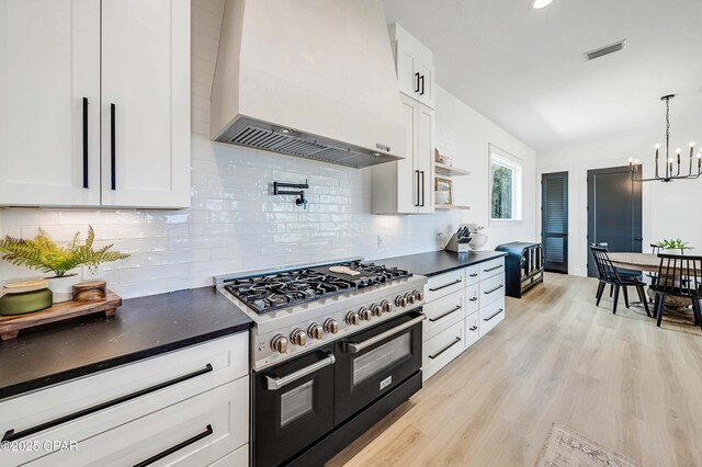 7603 Coastal Hammock Trl, Panama City Beach, FL 32413 - kitchen with range with two ovens, wall chimney exhaust hood, dark countertops, white cabinets, and recessed lighting