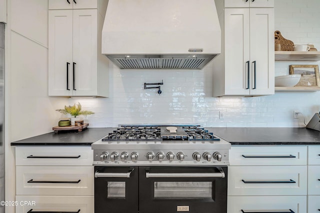7603 Coastal Hammock Trl, Panama City Beach, FL 32413 - kitchen featuring range with two ovens, ventilation hood, dark countertops, and white cabinetry