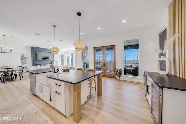 7603 Coastal Hammock Trl, Panama City Beach, FL 32413 - kitchen with dark countertops, beverage cooler, light wood-type flooring, dishwasher, and recessed lighting
