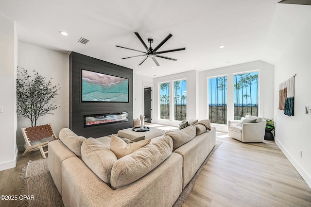 7603 Coastal Hammock Trl, Panama City Beach, FL 32413 - living room with a large fireplace, light wood-type flooring, recessed lighting, baseboards, and ceiling fan