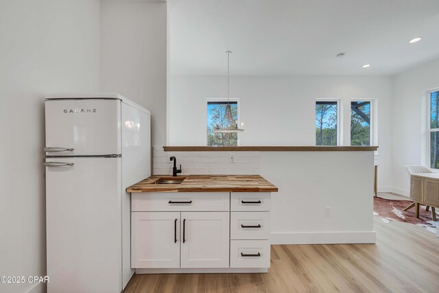 7603 Coastal Hammock Trl, Panama City Beach, FL 32413 - kitchen featuring freestanding refrigerator, butcher block countertops, light wood-style flooring, decorative backsplash, and recessed lighting