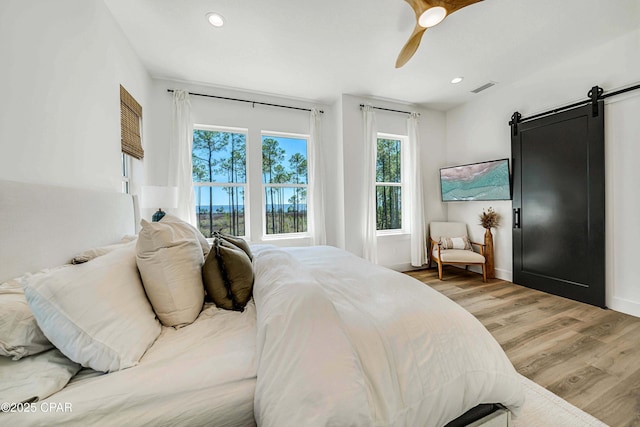 7603 Coastal Hammock Trl, Panama City Beach, FL 32413 - bedroom featuring light wood-type flooring, a barn door, a ceiling fan, recessed lighting, and baseboards