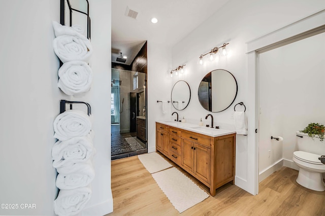 7603 Coastal Hammock Trl, Panama City Beach, FL 32413 - bathroom with wood finished floors, a shower stall, toilet, and double vanity