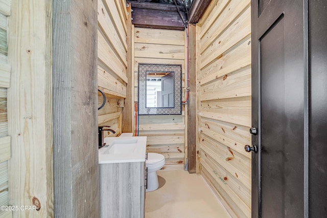 7603 Coastal Hammock Trl, Panama City Beach, FL 32413 - bathroom with toilet, vanity, concrete floors, and wood walls