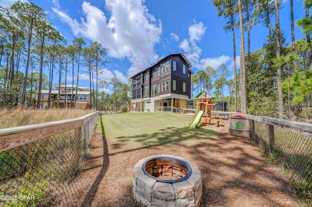 7603 Coastal Hammock Trl, Panama City Beach, FL 32413 - back of property with a playground, a fire pit, and board and batten siding