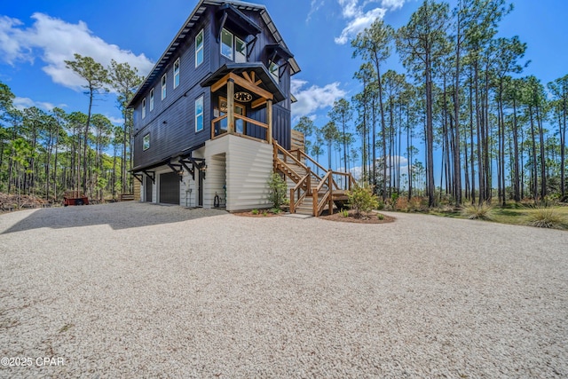 7603 Coastal Hammock Trl, Panama City Beach, FL 32413 - view of side of home featuring stairway, driveway, and a garage