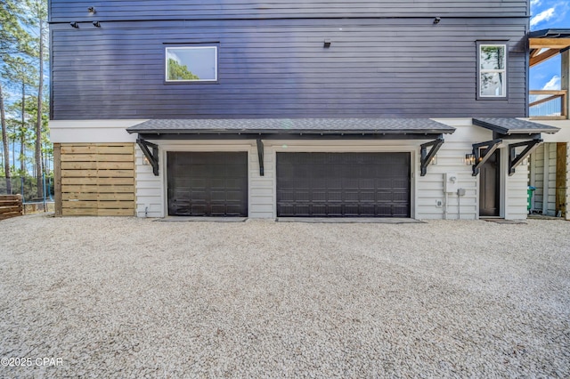 7603 Coastal Hammock Trl, Panama City Beach, FL 32413 - view of front of home featuring an attached garage, gravel driveway, and a shingled roof